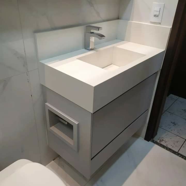 a white sink and toilet in a small room with tile flooring on the walls