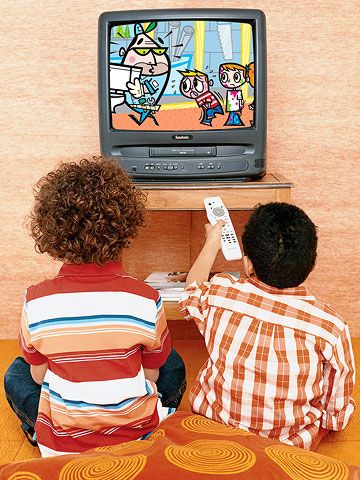 two young boys sitting in front of a tv playing video games