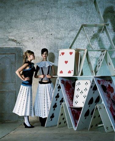 two women standing next to each other near playing cards