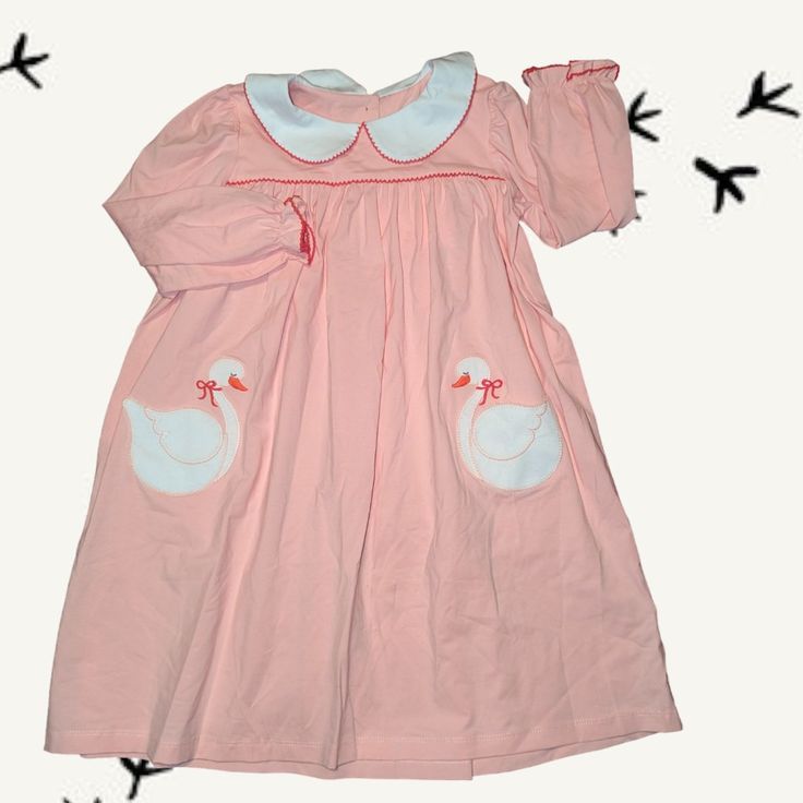 Whether She Is A Swan Princess Or A Queen, Your Daughter Is Sure To Love This Adorable, Classic Style, Swan Pocket Dress. It Features Soft Apricot Cotton Fabric, Which Is Sure To Keep Her Happy All Day Long, Red Picot Detailing Around The White Collar And Ruffle Sleeves, And Applique Giant Swan Front Pockets. This Sweet Dress Is Perfect For All Activities, Back To School, And Maybe A Disney Trip! Made From The Softest 100% Cotton For Ultimate Comfort Custom Red Buttons Down The Back Red Picot Tr Cute Long Sleeve Dress For Dress-up, Cute Long Sleeve Dress-up Dresses, Long Sleeve Playful Twirl Dress For Playdate, Playful Long Sleeve Twirl Dress For Playdate, Playful Ruffled Dress For Sleepovers, Playful Long Sleeve Playwear Dresses, Playful Long Sleeve Dresses For Playwear, Cute Spring Twirl Dress For Sleepovers, Playful Pink Dress For Playdate