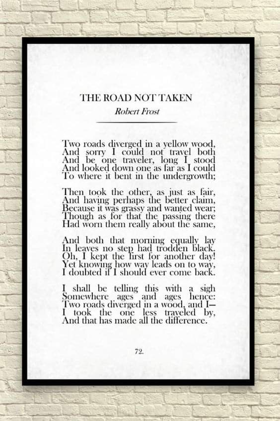 the road not taken by robert frost on a white brick wall with black border and frame