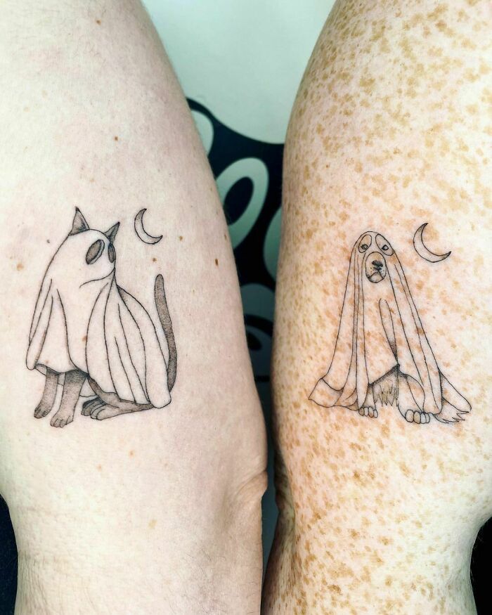 two people with tattoos on their legs, one has a cat and the other has a ghost