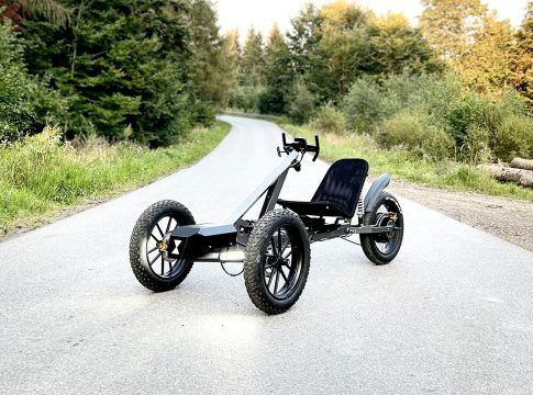 an off - road vehicle is parked on the side of the road in front of some trees