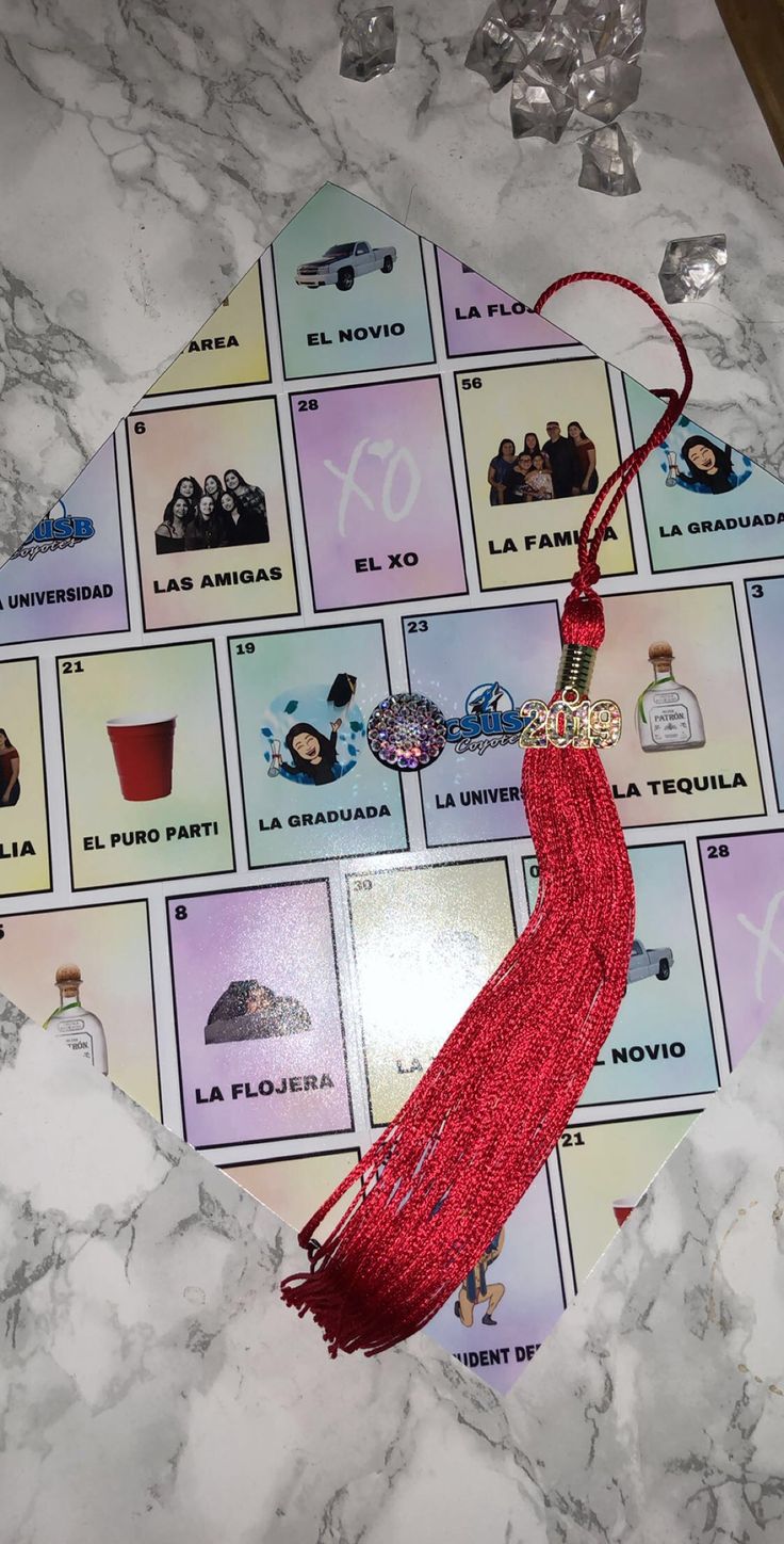 a red tassel hanging from the side of a white marble counter top with pictures on it