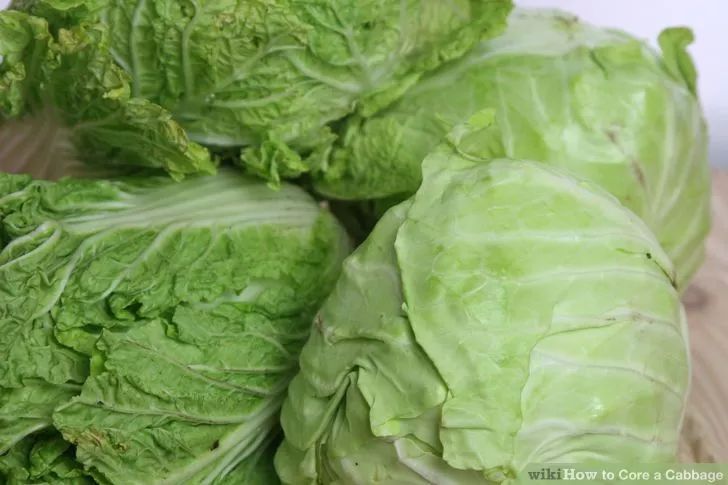 some green lettuce sitting on top of a wooden table