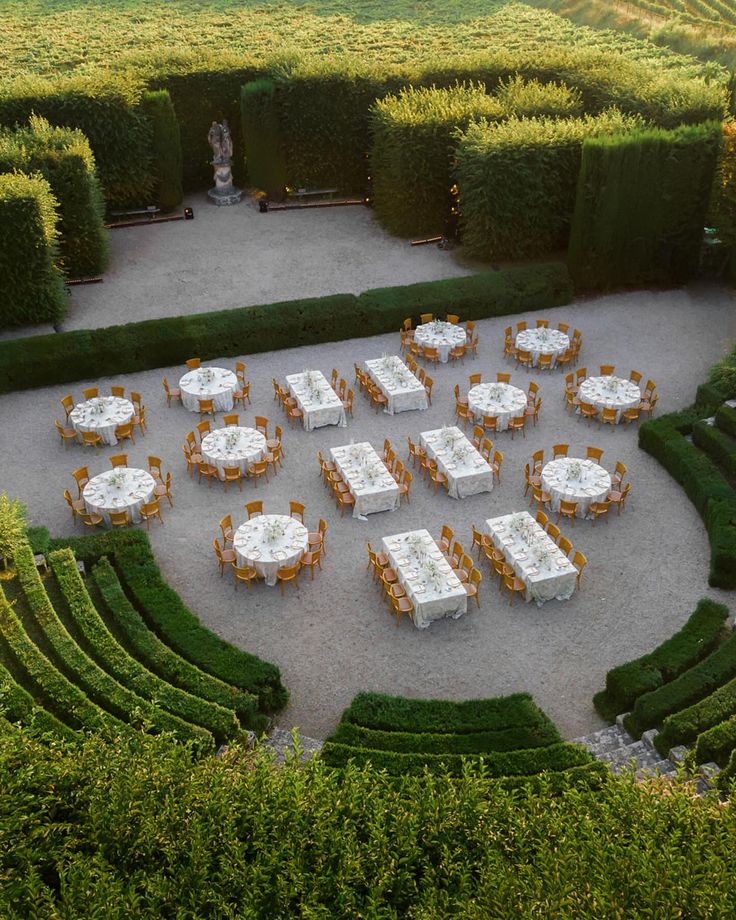 an aerial view of tables and chairs in the middle of a mazed garden area