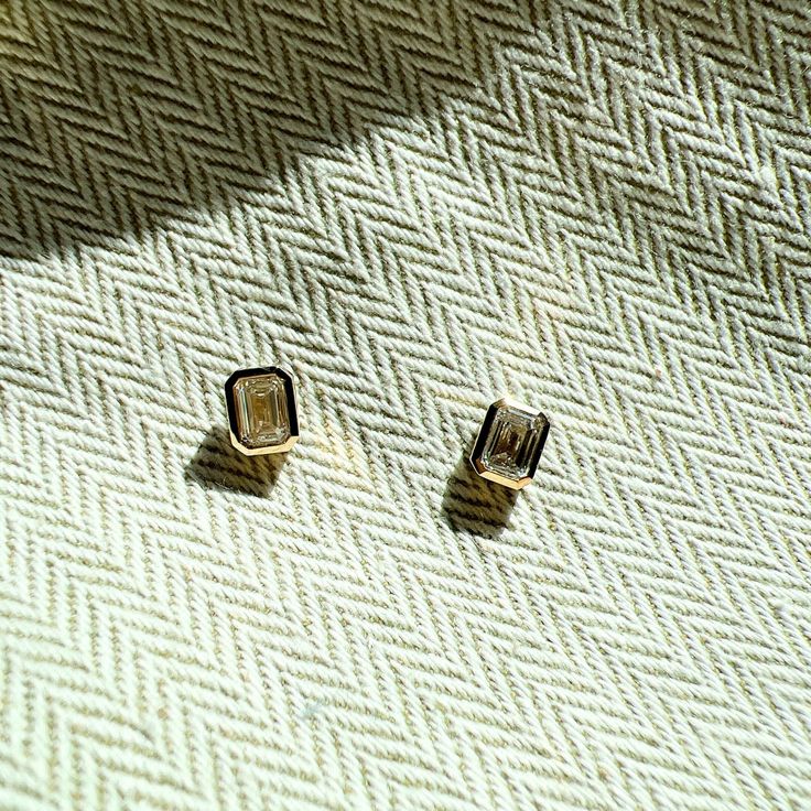 Made with the highest color grade diamonds in a bezel setting, these earrings exude sophistication and timeless elegance. Let their beauty and brilliance shine, and add a touch of luxury to any outfit. Diamond is set in 14k solid recycled yellow gold Friction Post Back. Bezel setting Sold as a pair. AG Conflict-free, socially responsible diamonds. Color: D-F, Clarity: VS+, Cut: Excellent Total carat weight: Offering 1.0 ct per pair Shape: Emerald cut Luxury Yellow Gold Earrings With Bezel Setting, Formal Gold Bezel Set Earrings, Modern Yellow Gold Bezel Setting Earrings, Minimalist Bezel Set Diamond Earrings For Formal Occasions, Luxury Gold Earrings With Bezel Setting, Minimalist Diamond Earrings With Bezel Setting For Formal Occasions, Minimalist Formal Diamond Earrings With Bezel Setting, Timeless Diamond Earrings With Polished Finish For Gifts, Modern Bezel Set Earrings For Formal Occasions