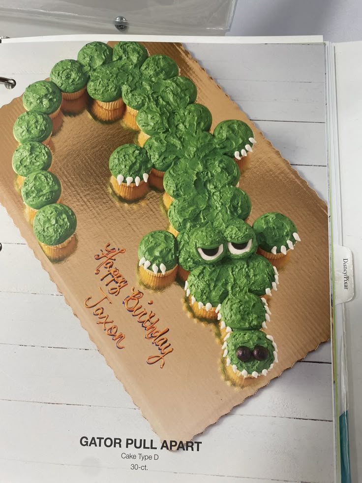 there are cupcakes made to look like an alligator on top of a card