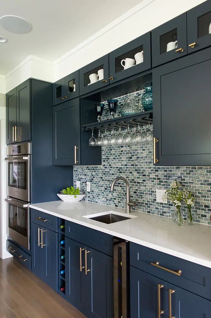 a kitchen with dark blue cabinets and white counter tops is seen in this image from the front view