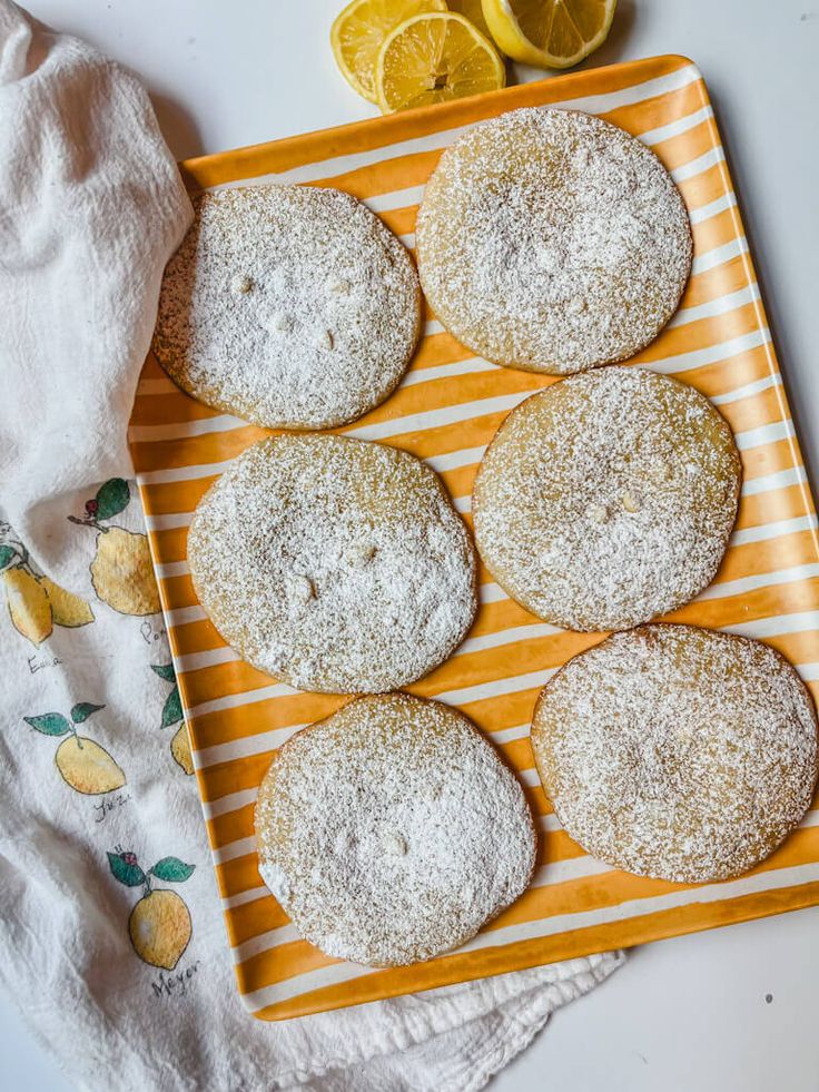 powdered sugar cookies on a plate with lemons