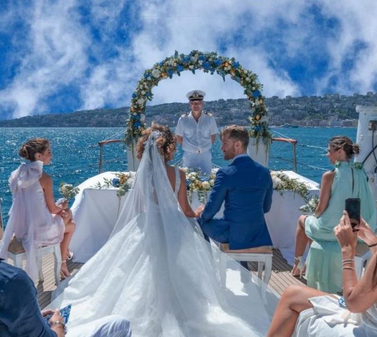 a couple getting married on a boat in the ocean