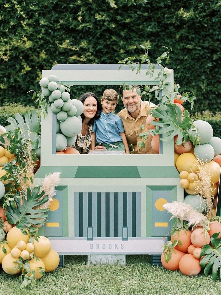 a family is posing for a photo in front of a truck decorated with fruits and vegetables