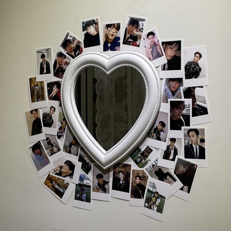 a heart shaped mirror surrounded by many photos