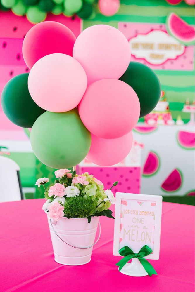 there is a potted plant with flowers and balloons in it on top of the table