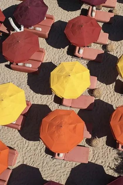 an overhead view of beach chairs and umbrellas