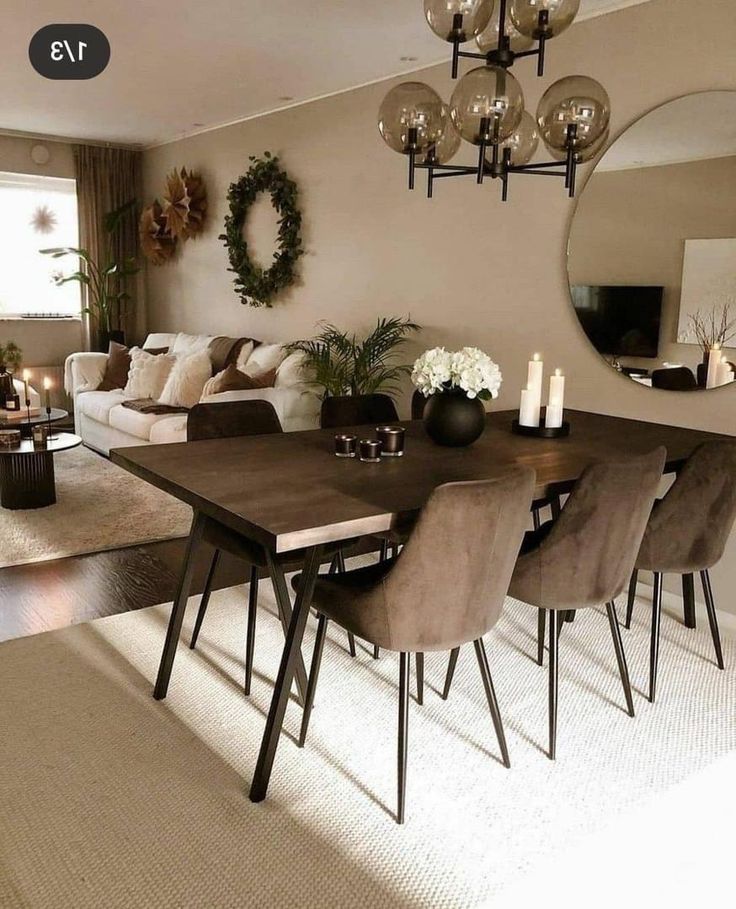 a dining room table with chairs and a mirror on the wall in front of it