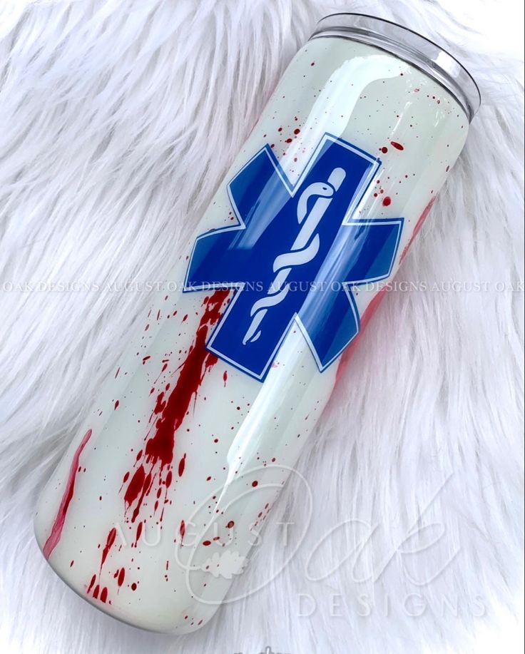 a white can with red blood on it and a blue medical cross in the center