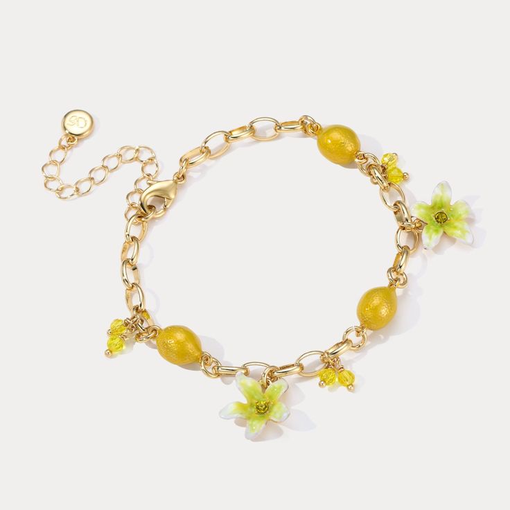 Experience the refreshing and invigorating essence of the Lemon Bracelet. Embrace nature with its sweet, juicy lemon design that evokes memories of sunny days, tropical vacations, and cool breezes. Let its vibrant flowers and fruit design add a touch of summer zeal to your style. Embrace the zesty spirit of summer and Celebrate the luxurious pleasures of nature's bounty with this delightful Lemon Bracelet! DETAILS Plating: 18K Gold Materials: 18K Gold on Brass, Enamel, Cubic Zirconia Measurement Elegant Beach Bracelets For Spring, Elegant Spring Beach Bracelets, Delicate Gold Bracelets For Summer, Elegant Yellow Flower Bracelets, Elegant Yellow Flower Bracelet, Summer Flower Charm Bracelet Jewelry, Dainty Beach Jewelry For Spring, Dainty Spring Beach Jewelry, Yellow Flower Bracelets For The Beach