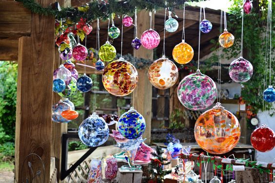 many colorful glass ornaments hanging from a wooden structure