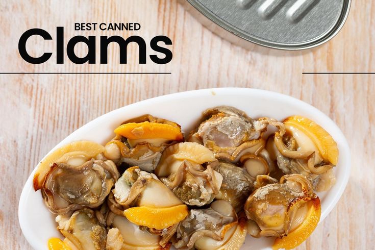 a white bowl filled with clams on top of a wooden table