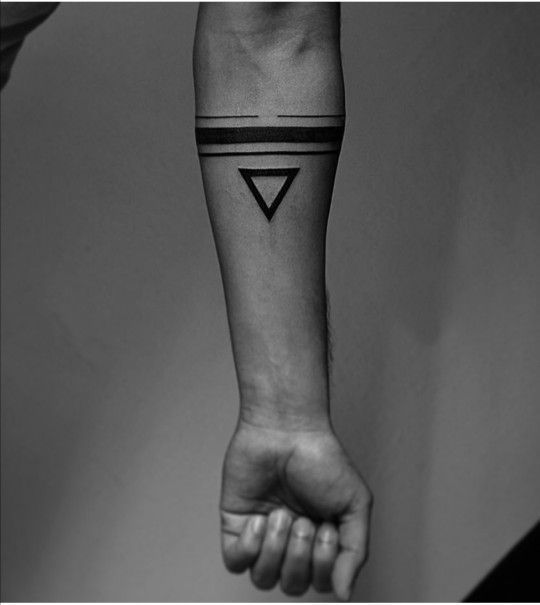 a person's arm with a black and white triangle tattoo on the left wrist