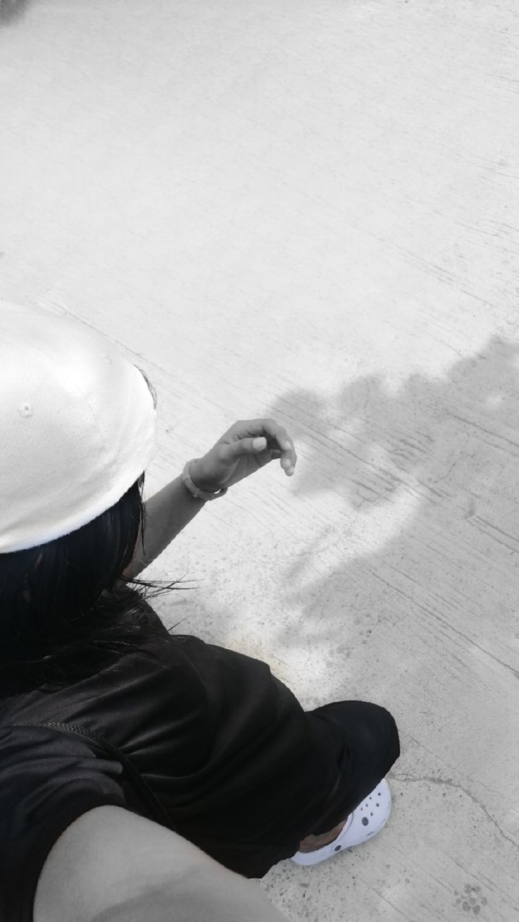 a woman sitting on the ground pointing at something