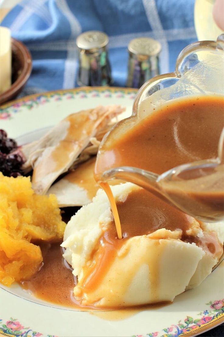 a plate with mashed potatoes, gravy, and other foods on it