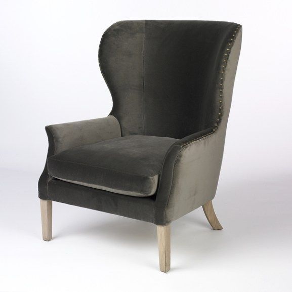 a gray chair with wooden legs and studding on the armrests, against a white background