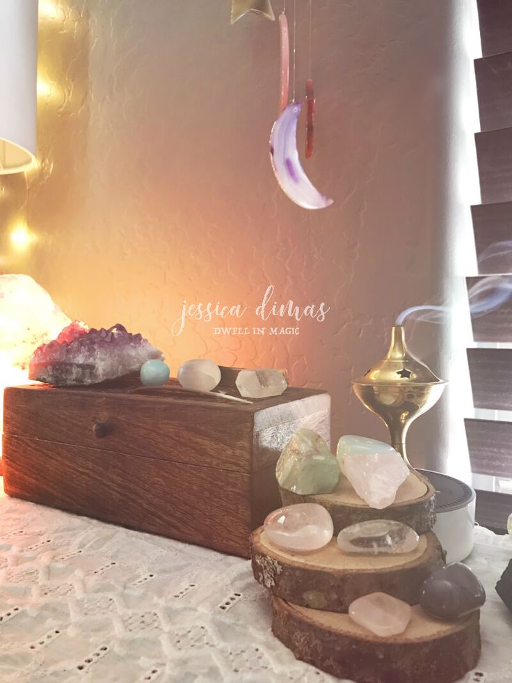 a wooden box sitting on top of a table next to a lamp and some rocks