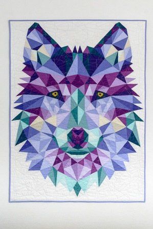 a quilt made to look like a wolf's head with geometric shapes on it