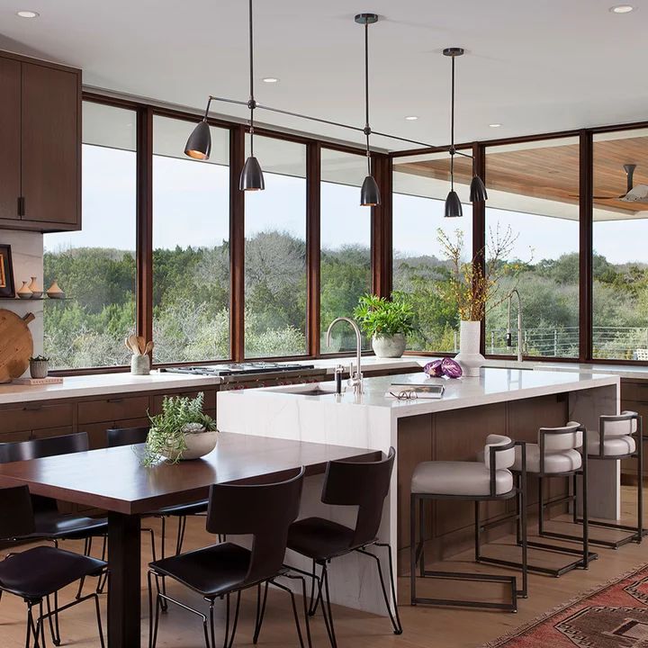 a large kitchen with an island in the middle and lots of windows on both sides