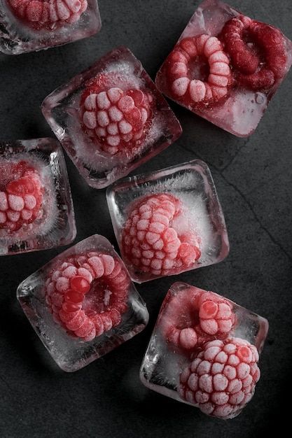 raspberries in ice cubes on a black surface