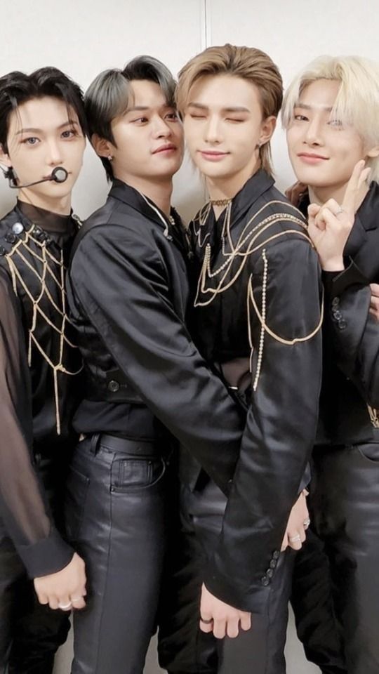 group of young men in black leather outfits posing for the camera with their hands on their hips