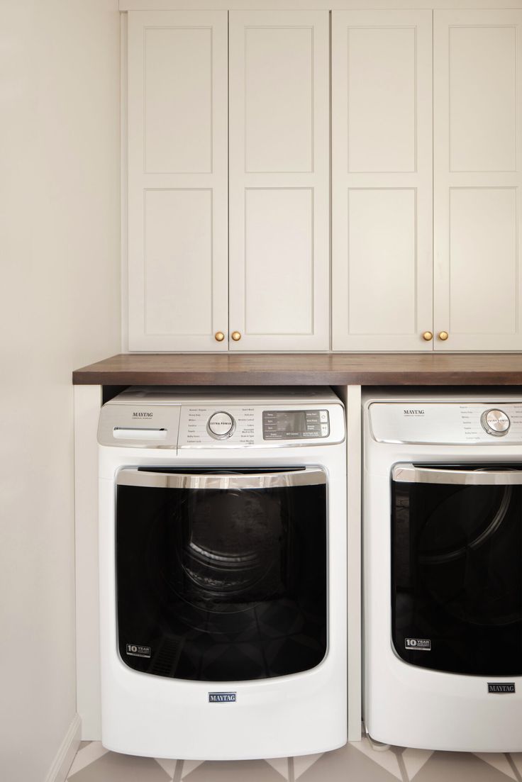 two white washers sitting next to each other in a kitchen