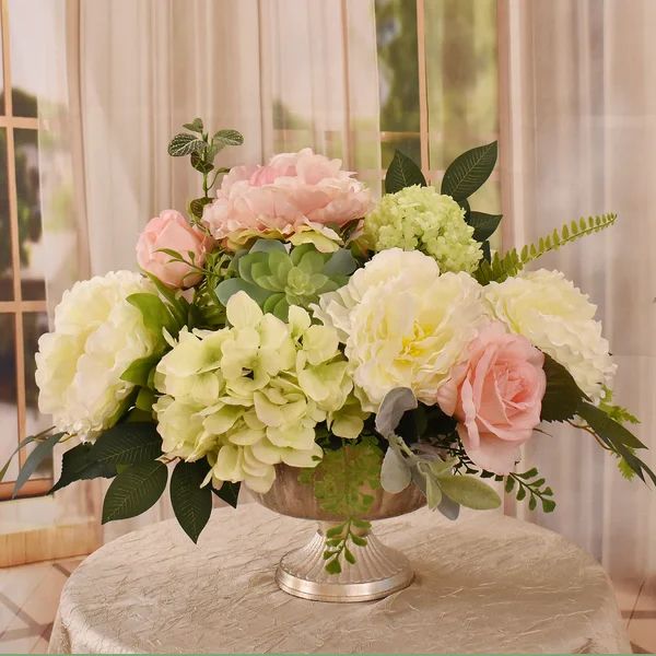 a vase filled with flowers sitting on top of a white table next to a window