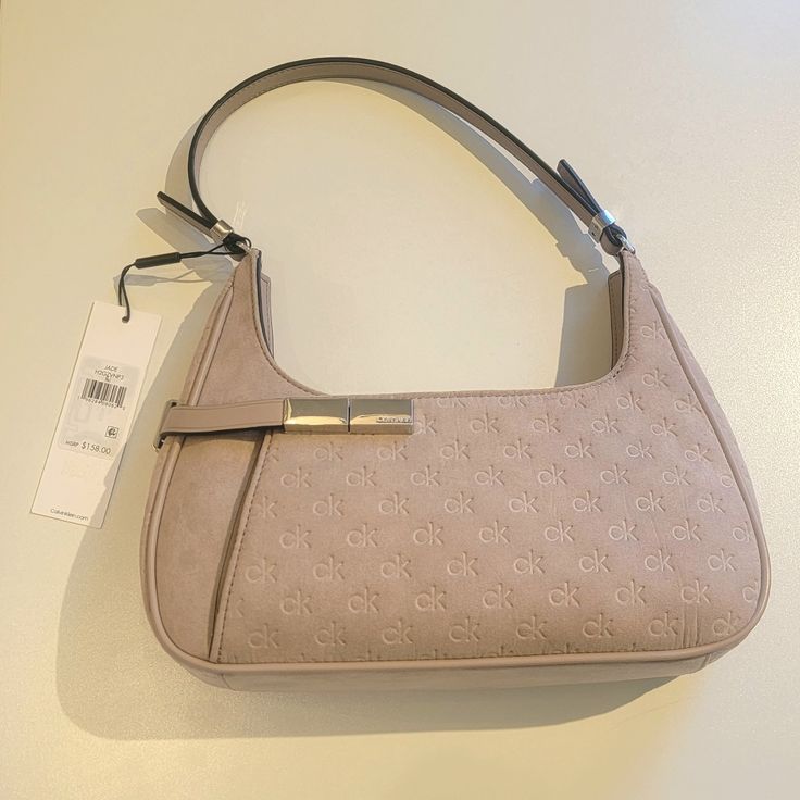 Calvin Klein Jade Signature Embossed Top Zipper Shoulder Bag Very Soft Lilac (Light Purple Pink) Color Lots Of Space Inside. I Love The Outside Buckle That Opens A Smaller Pocket On The Front Material: 100% Polyester Or Faux Suede; Trim: Polyester; Lining: Polyester Measurements: Small Size Bag, 11 5/8" W X 9" H X 1 3/4" D Strap Type: 9.75" Handle Drop Top Zipper Closure Exterior Details: 1 Exterior Slip Pocket Interior Details: Interior Single Slip Pocket, Interior Zip Pocket Silver Tone Hardwa Classic Calvin Klein Shoulder Bag For Formal Occasions, Classic Calvin Klein Formal Shoulder Bag, Elegant Calvin Klein Evening Shoulder Bag, Chic Formal Calvin Klein Shoulder Bag, Elegant Calvin Klein Shoulder Bag For Formal Occasions, Elegant Calvin Klein Shoulder Bag With Silver-tone Hardware, Elegant Spring Bags With Branded Hardware, Elegant Calvin Klein Bag For Formal Occasions, Elegant Calvin Klein Formal Bag