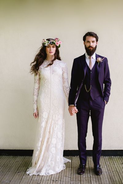 a bride and groom holding hands while standing next to each other on a wooden floor