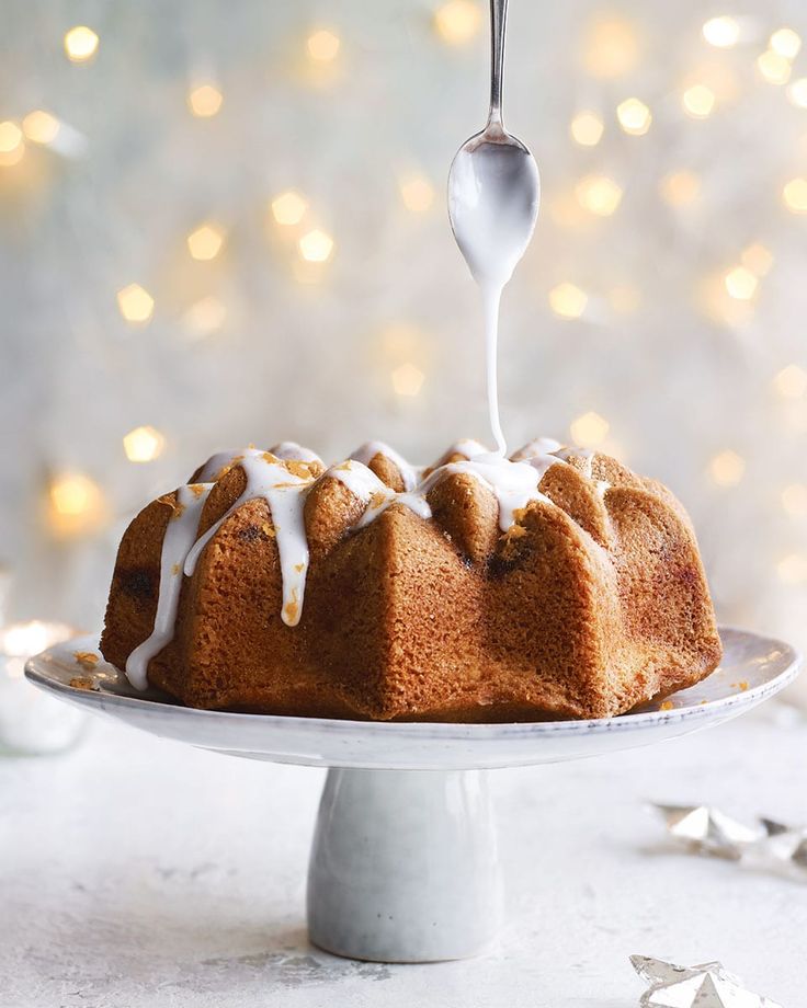 a bundt cake is being drizzled with icing on a plate