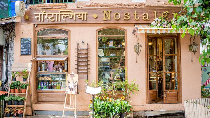 a store front with lots of potted plants in front of it and the words nostalia written on the door