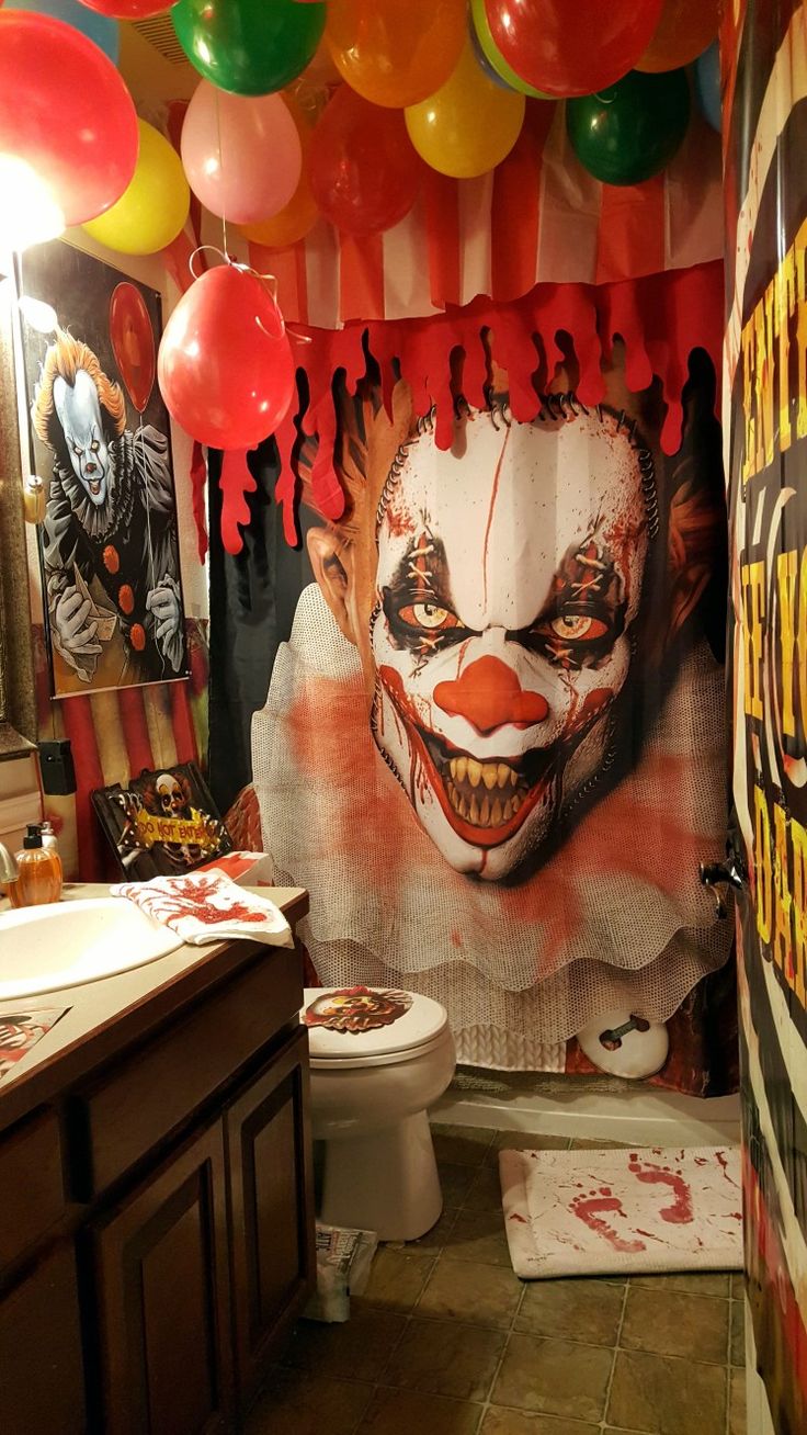 a bathroom decorated for halloween with clowns and balloons