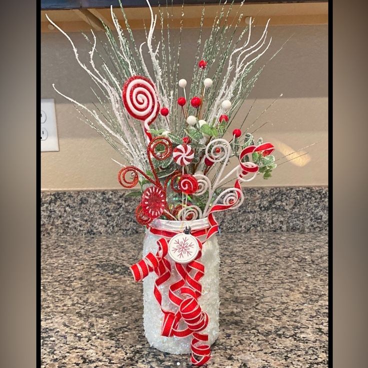 a vase filled with candy canes on top of a counter