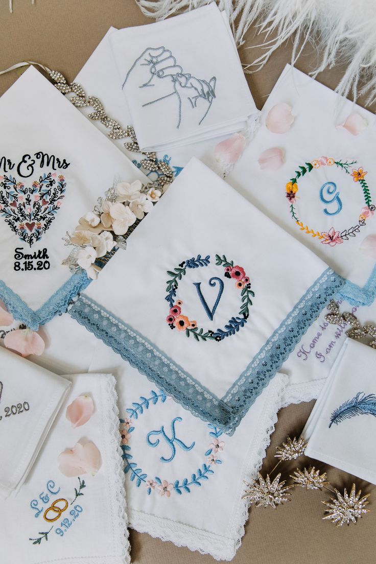 embroidered wedding handkerchiefs and napkins are laid out on a table