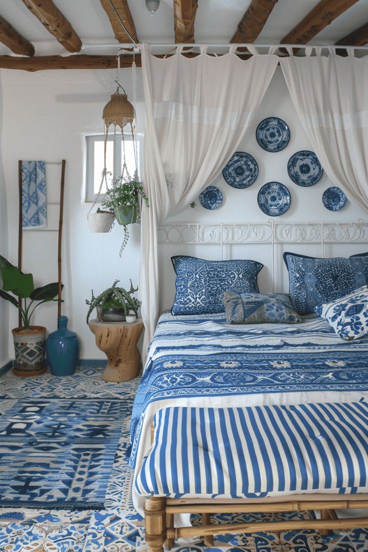 a bed with blue and white decor in a bedroom next to a potted plant