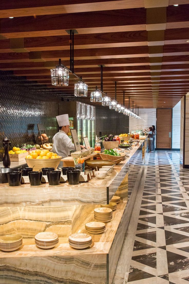 a chef standing in front of a counter filled with food