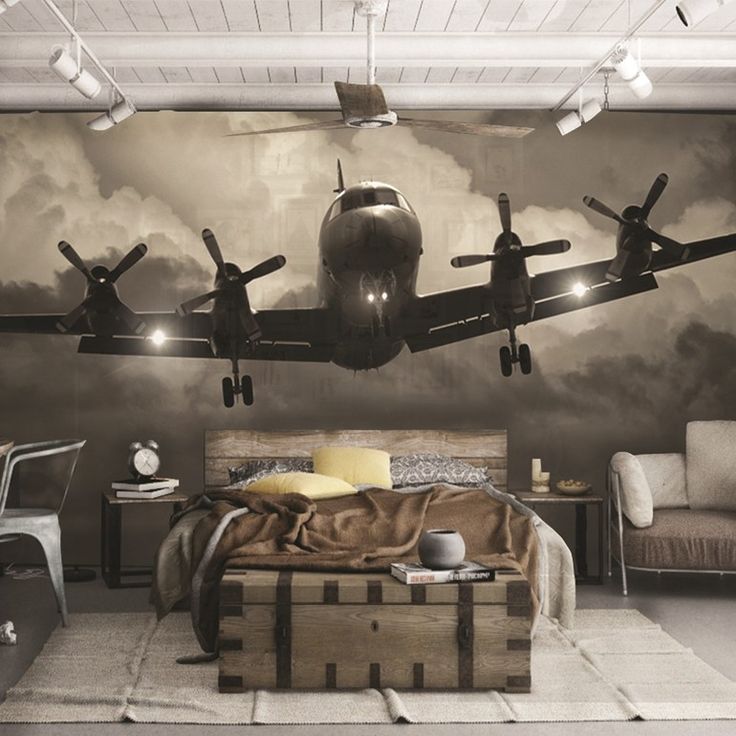 an airplane is flying in the sky above a bed and desk with a suitcase on it