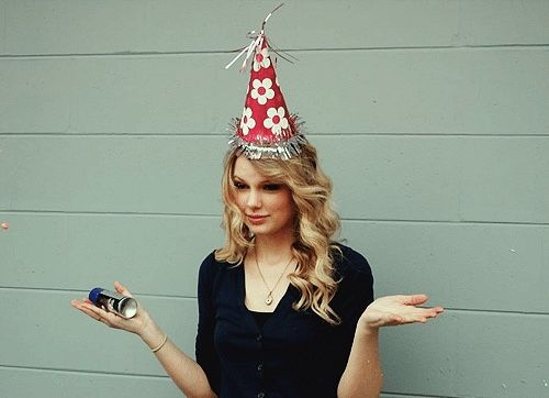 a woman wearing a birthday hat and holding a cell phone