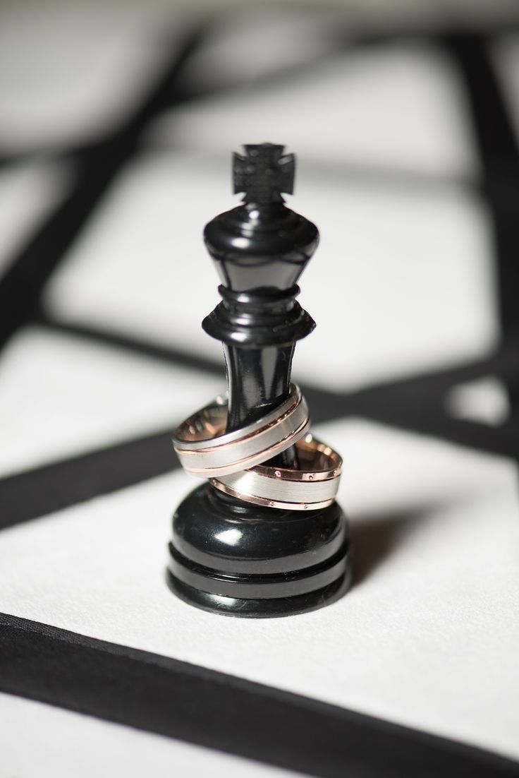 a black and white chess piece with two rings on it