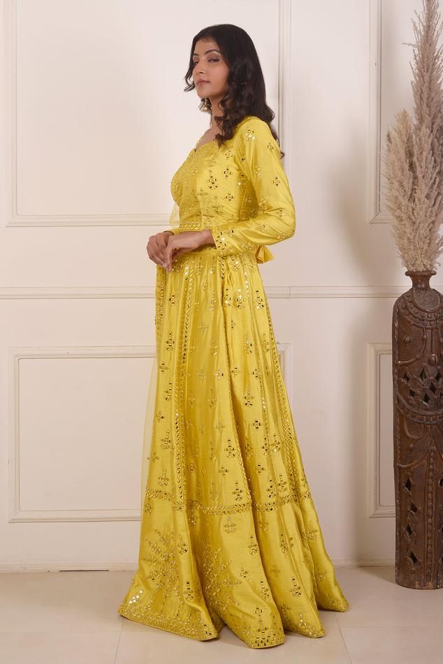 Yellow lehenga with mirror embroidery crafted in dupion. Paired with a long sleeve embroidered blouse and viscose net dupatta.
Components: 3
Pattern: Embroidered
Type Of Work: Mirror
Neckline: Leaf
Sleeve Type: Long
Fabric: Lehenga and Blouse: Dupion, Dupatta: Viscose Net
Color: Yellow
Other Details: 
Mirror work
Back tassel tie-up
Length:
Lehenga: 42 inches
Blouse: 15.5 inches
Dupatta: 2.5 mtrs
Occasion: Mehendi and Haldi - Aza Fashions Festive Lehenga With Straight Kurta For Reception, Floor-length Sets With Resham Embroidery For Festive Occasions, Floor-length Festive Sets With Resham Embroidery, Floor-length Chinon Sets With Resham Embroidery, Festive Floor-length Sets With Resham Embroidery, Long Sleeve Gown For Eid Reception, Floor-length Chanderi Sets With Resham Embroidery, Reception Lehenga With Zari Work And Straight Kurta, Eid Reception Dresses With Gota Work