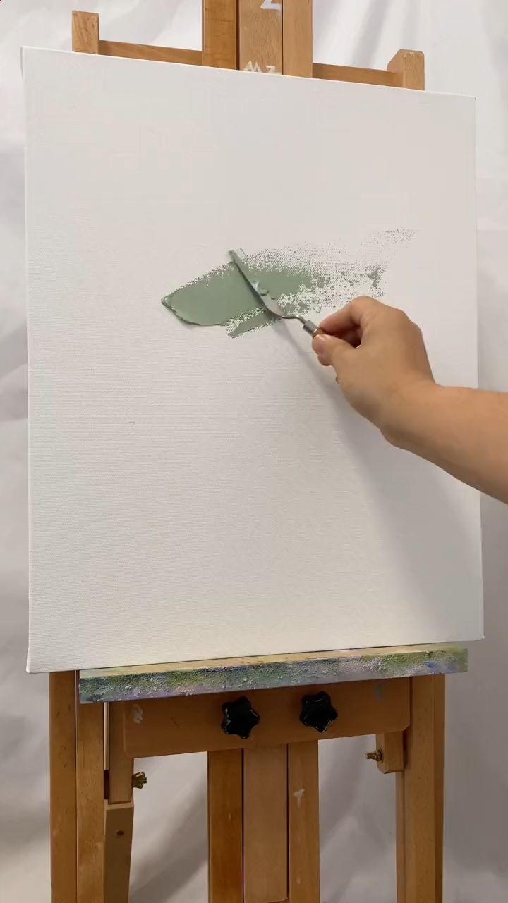 a person using a paint brush on a piece of paper