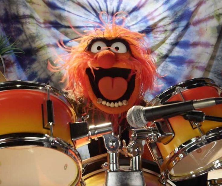 the muppet is playing drums in front of an image of his face and mouth